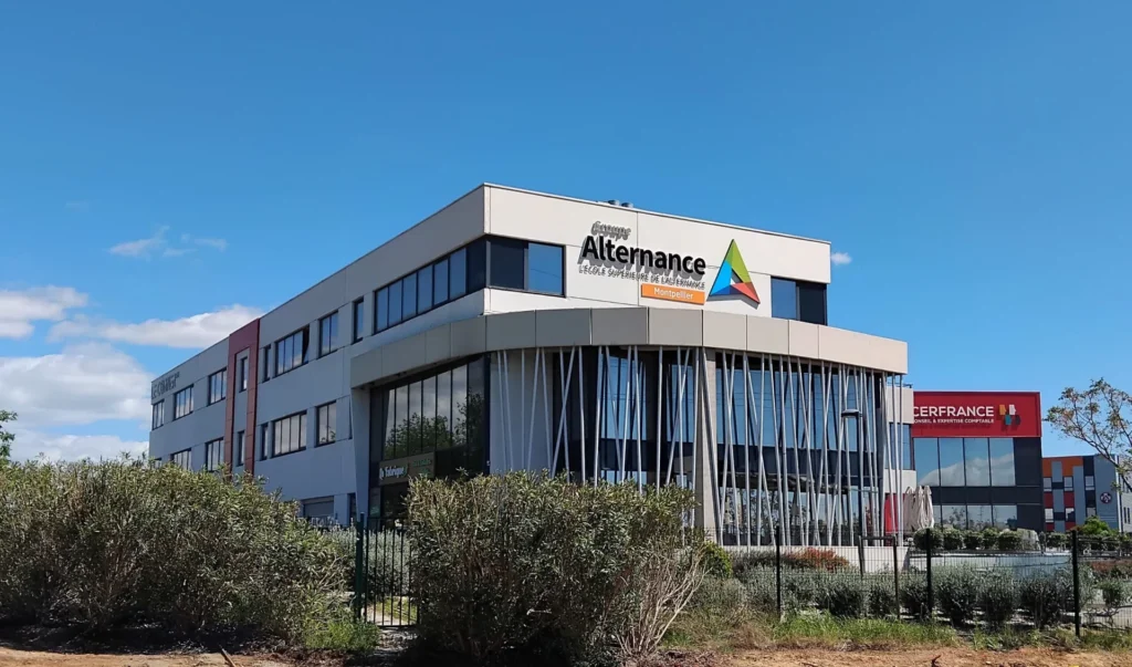 Le bâtiment moderne du Groupe Alternance, école supérieure de l'apprentissage, avec un logo coloré et des grandes fenêtres.